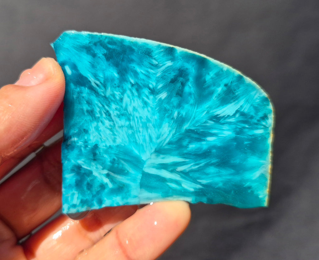 Teal blue chatoyant glass slab 49g - hand held view