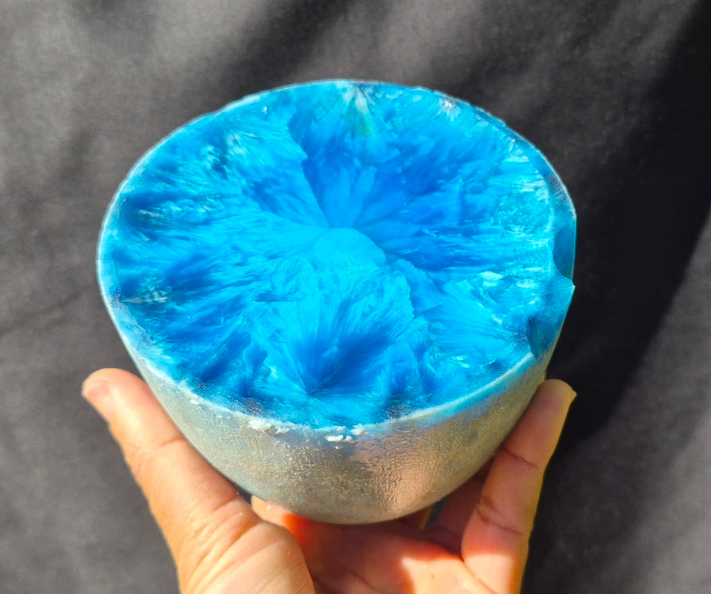 Cyan blue chatoyant glass boule 1455g - hand held view showing radiating crystal formations