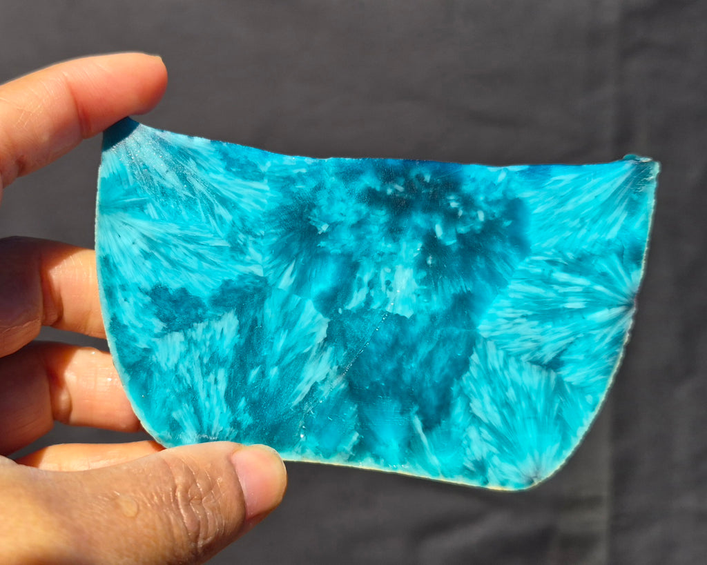 Teal blue chatoyant glass slab 121g - hand held view