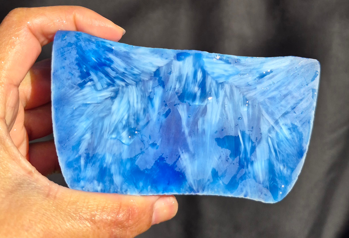 Blue raw chunk 655g – SBSR 119, hand held showing vivid blue chatoyancy