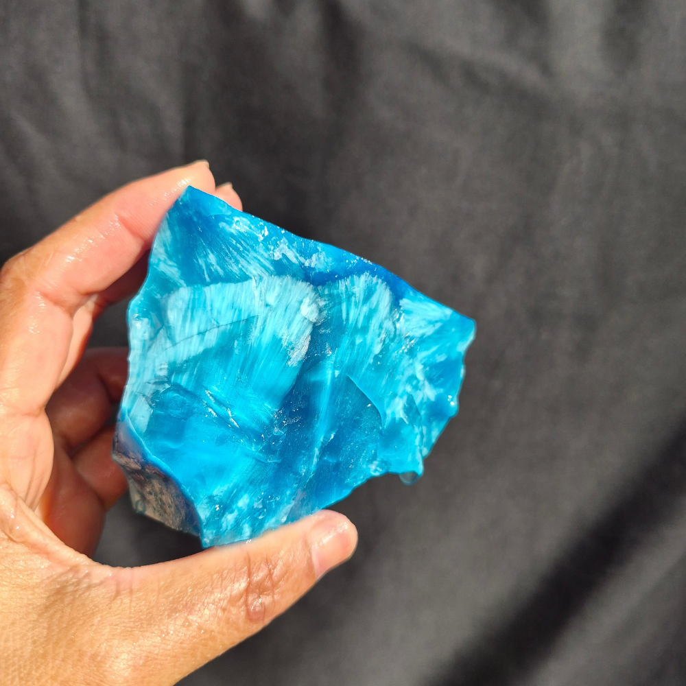 Blue chatoyant glass raw chunk SBSR 128 - hand held front view