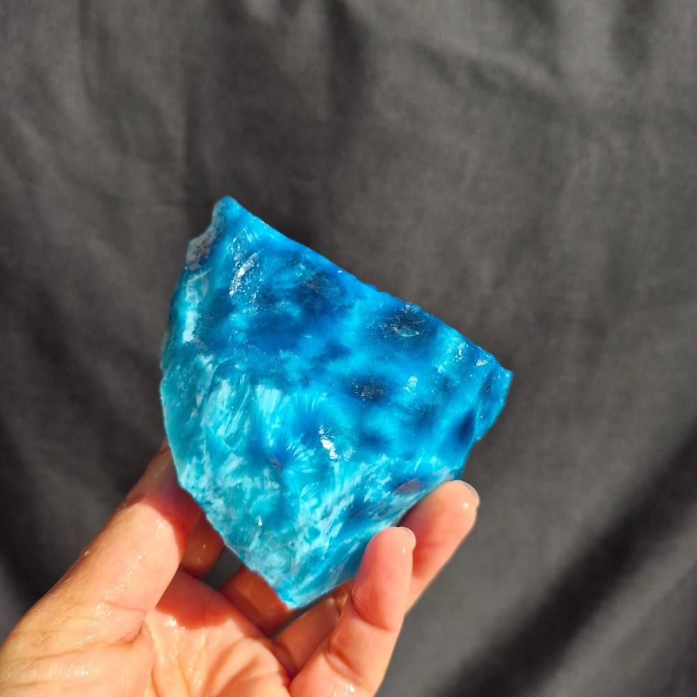 Blue chatoyant glass raw chunk SBSR 128 - hand held side view